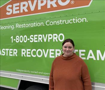 Female employee Brittany Long standing in front of a SERVPRO vehicle